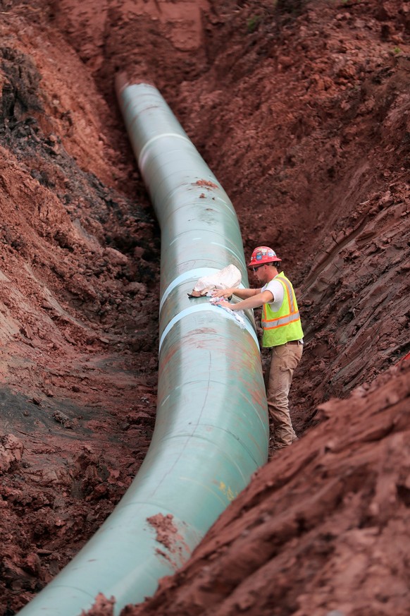 FILE - In this Aug. 21, 2017, file photo, a pipe fitter lays the finishing touches to the replacement of Enbridge Energy&#039;s Line 3 crude oil pipeline stretch in Superior, Wisc. After President Joe ...