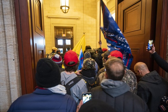epa08926299 Supporters of US President Donald J. Trump and his baseless claims of voter fraud run through the halls of the US Capitol after breaching Capitol security during their protest against Cong ...
