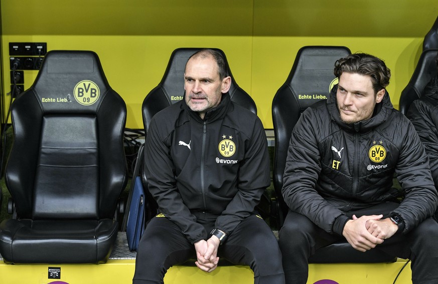 FILE - In this Saturday, Feb. 9, 2019 file photo Dortmund&#039;s assistant coaches Manfred Steves, left, and Edin Terzic sit beside the empty seat of head coach Lucien Favre, during the German Bundesl ...