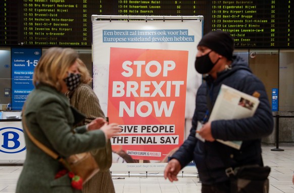 epa08889799 Commuters pass an anti-Brexit billboard made by the KU Leuven University at the Central Station in Brussels, Belgium, 17 December 2020. A negotiations phase of eleven months that started o ...