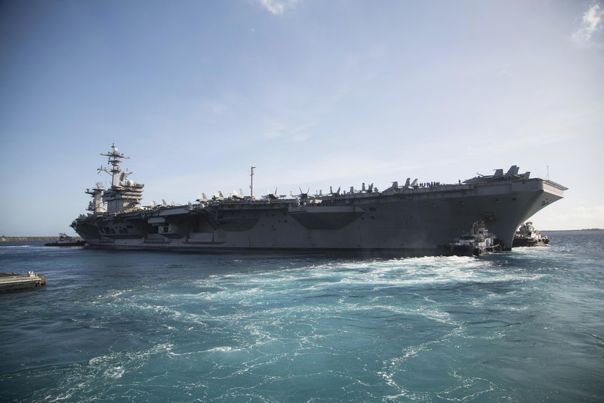In this photo provided by the U.S. Marine Corps, the aircraft carrier USS Theodore Roosevelt (CVN 71) departs Apra Harbor at Naval Base Guam on Thursday, May 21, 2020, following an extended visit to G ...