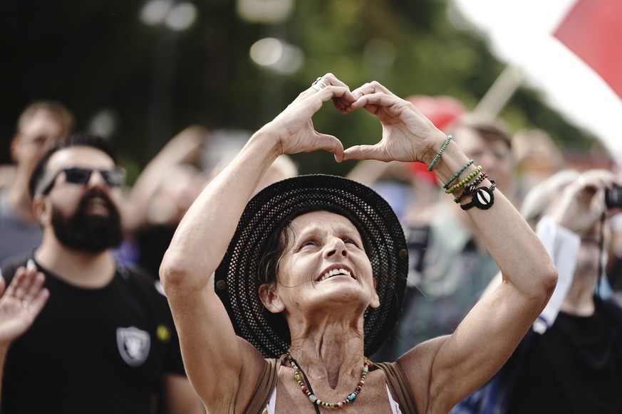 A participant forms a heart with her hands during a demonstration against the corona measures of the German Government in Berlin, Germany, Saturday, Aug. 29, 2020. (Kay Nietfeld/dpa via AP)