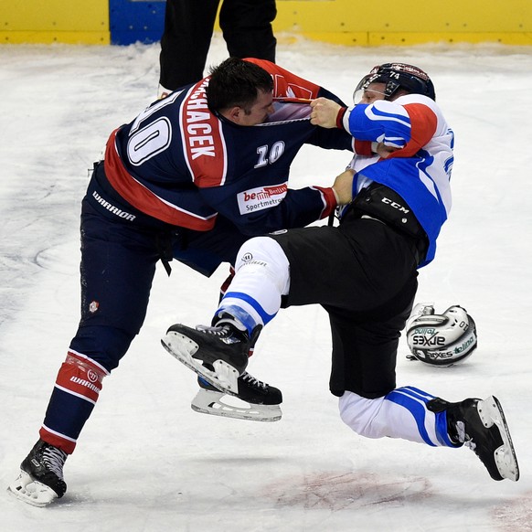 Berlin&#039;s Spencer Machacek, left, fights againt Zug&#039;s Johann Morant, during the Champions League round of 32 ice hockey match between Eisbaeren Berlin and EV Zug, in Berlin, Germany, on Tuesd ...