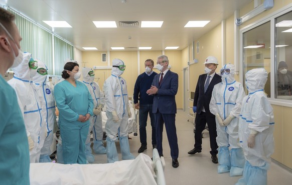 In this photo provided by Moscow&#039;s Major Press Service, Moscow Mayor Sergei Sobyanin, center right, speaks to medical staff as he visits the new infectious diseases hospital on the outskirts of M ...