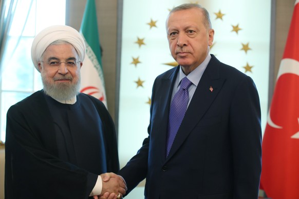 epa07846290 A handout photo made available by the Turkish Presidential press office shows Turkish President Recep Tayyip Erdogan (R) welcomes Iranian President Hassan Rouhani (L) before their meeting  ...