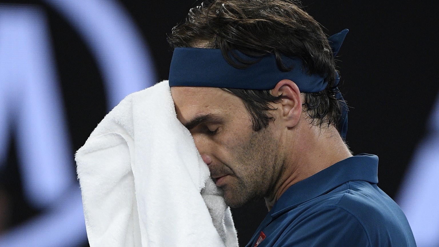 Switzerland&#039;s Roger Federer wipes the sweat from his face during his fourth round match against Greece&#039;s Stefanos Tsitsipas at the Australian Open tennis championships in Melbourne, Australi ...