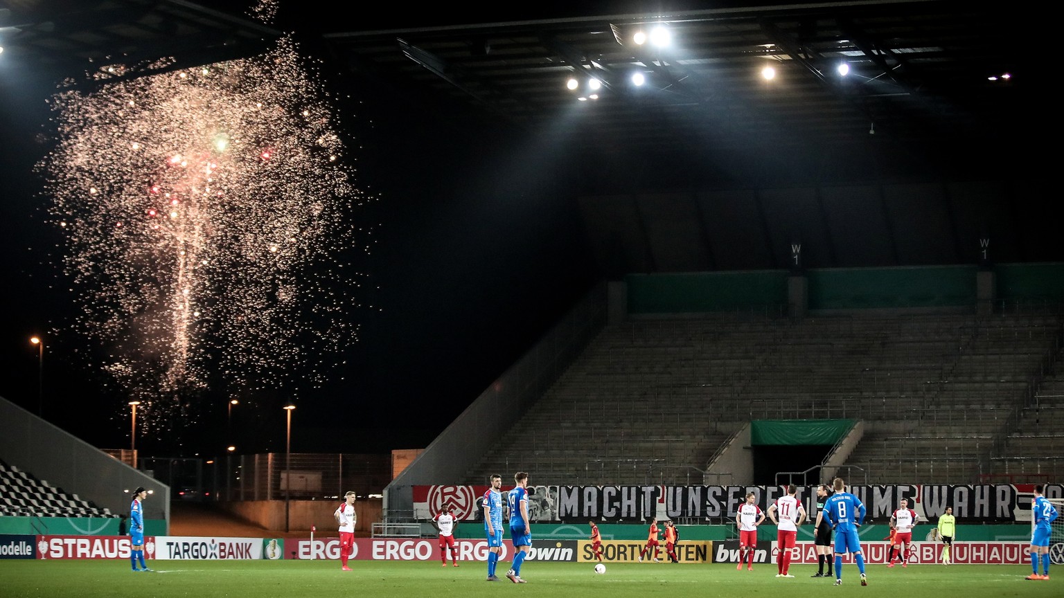 epa09049305 Fireworks illuminate the sky outside the stadium after Kiel scored the 1-0 lead during the German DFB Cup quarter final soccer match between Rot-Weiss Essen and Holstein Kiel in Essen, Ger ...