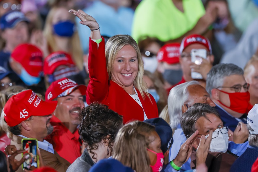 epa08751761 Republican Georgia Congressional candidate and QAnon promoter Marjorie Taylor Greene is recognized by US President Donald J. Trump as he speaks at his Make America Great Again Rally campai ...