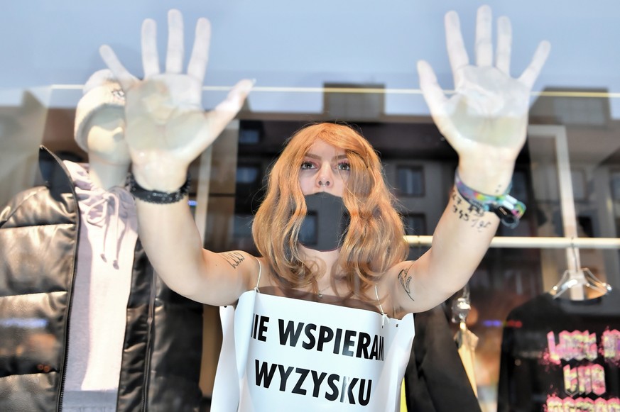 epaselect epa08846084 Extinction Rebellion Wroclaw activist, covered with placard &#039;I do not support exploitation&#039; during the &#039;Naked protest on Black Friday&#039; in a store in Wroclaw,  ...