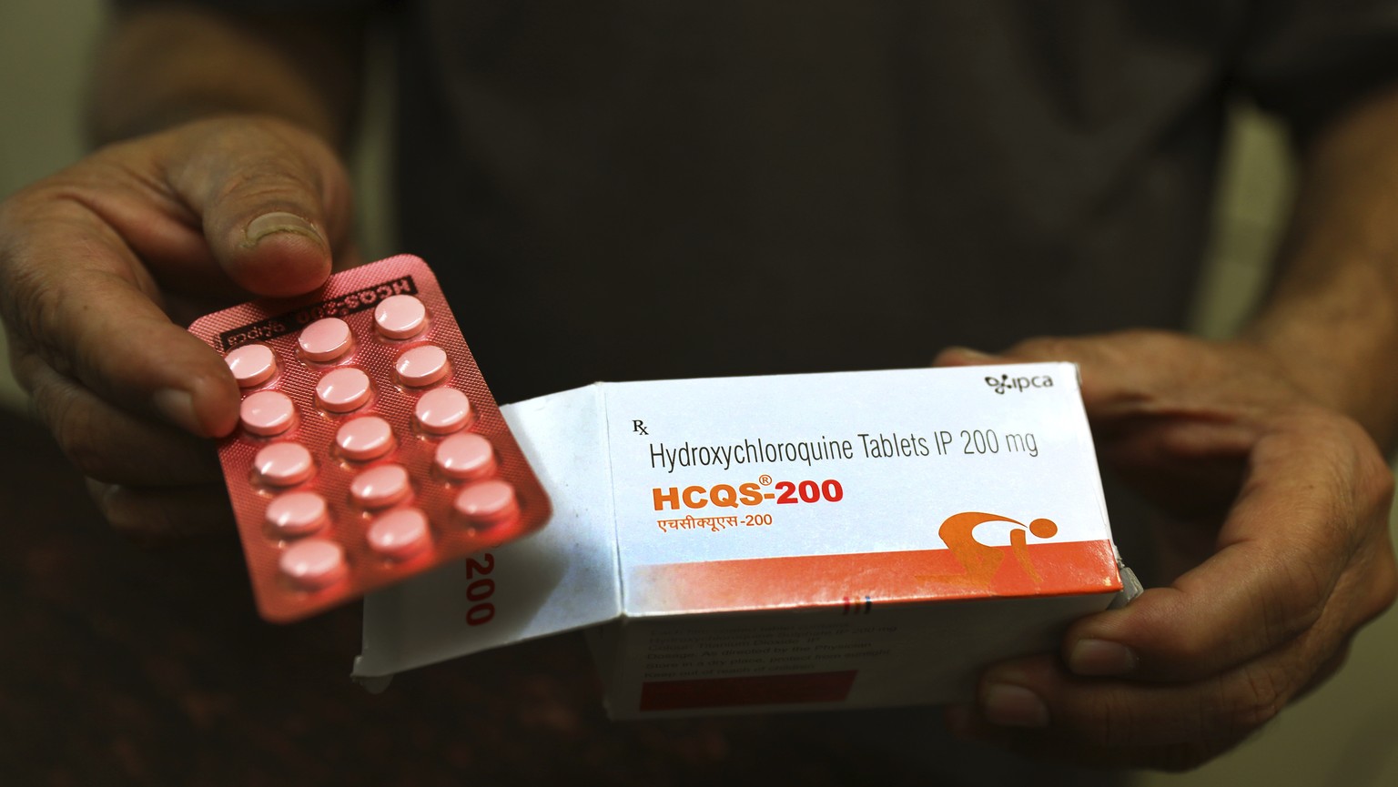 FILE - In this Thursday, April 9, 2020 file photo, a chemist displays hydroxychloroquine tablets in New Delhi, India. Scientists in Brazil have stopped part of a study of the malaria drug touted as a  ...