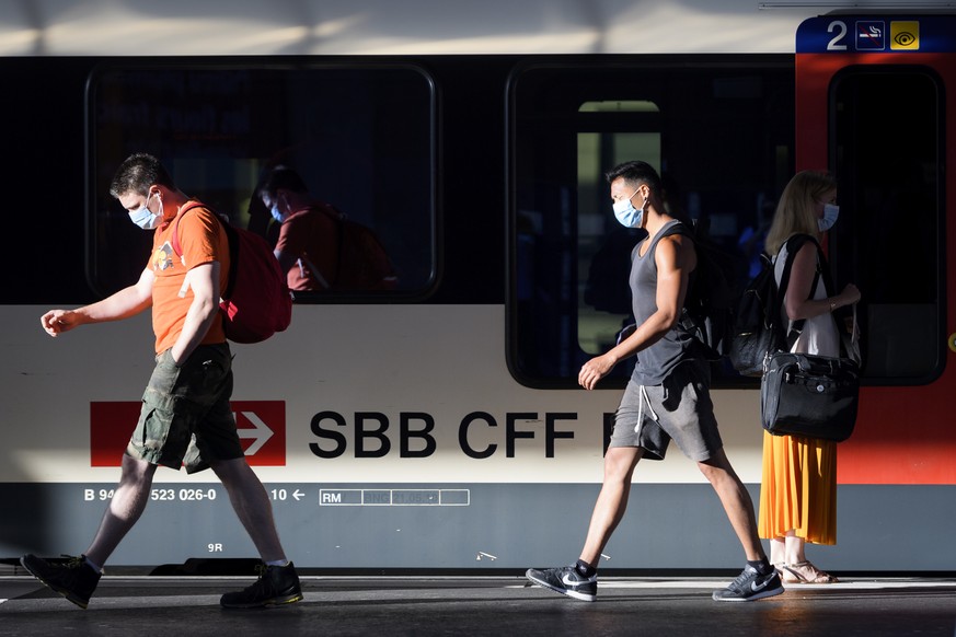 People wearing protective mask get out a SBB CFF train during the coronavirus disease (COVID-19) outbreak, at the train station CFF in Lausanne, Switzerland, Monday, July 6, 2020. In Switzerland, from ...