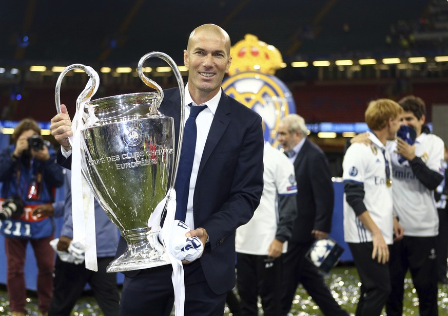 Real Madrid&#039;s head coach Zinedine Zidane celebrates with the trophy at the end of the Champions League soccer final between Juventus and Real Madrid at the Millennium Stadium in Cardiff, Wales, S ...
