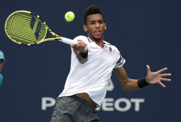 Felix Auger-Aliassime, of Canada, returns to John Isner during their semifinal match at the Miami Open tennis tournament, Friday, March 29, 2019, in Miami Gardens, Fla. (AP Photo/Lynne Sladky)