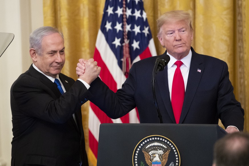 epa08173200 US President Donald J. Trump (R) shakes hands with Prime Minister of Israel Benjamin Netanyahu while unveiling his Middle East peace plan in the East Room of the White House, in Washington ...