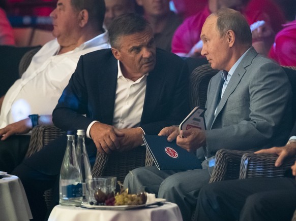 Russian President Vladimir Putin, right, and International Ice Hockey federation President Rene Fasel, left, talk to each other as they attend an international tournament in professional Sambo Plotfor ...
