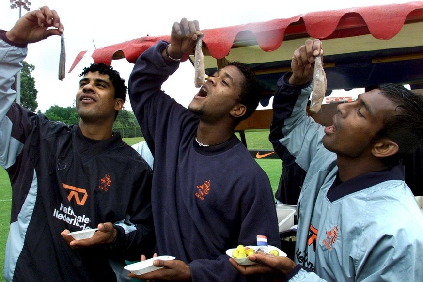 NL01 - 20000530 - NYON, SWITZERLAND : Dutch coach Frank Rijkaard and players Patrick Kluivert and Aron Winter try the first haring (the so-called Hollandse Nieuwe), flown in from Amsterdam, in their t ...