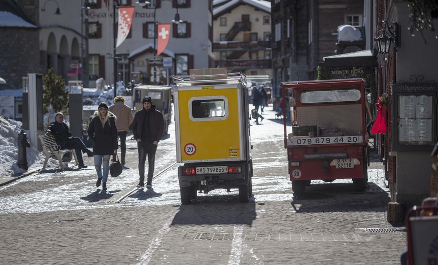 An electric vehicle of the Swiss post next to another electric vehicle in Zermatt, Canton of Valais, Switzerland, on February 13, 2019. (KEYSTONE/Christian Beutler)