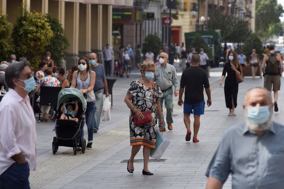 epa08545512 Passersby wear facial masks in Zaragoza, Aragon, Spain, 14 July 2020. Aragon has announced facial masks are mandatory from 14 July 2020, after Zaragoza and Huesca cities and surroundings w ...