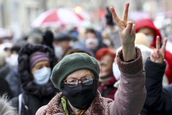 A woman wearing a face mask to protect against coronavirus gestures as she attends a pensioners&#039; opposition rally to protest the official presidential election results in Minsk, Belarus, Monday,  ...