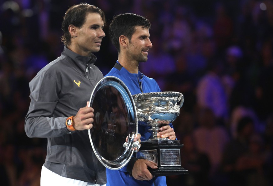 Serbia&#039;s Novak Djokovic, right, holds his trophy as he stands with Spain&#039;s Rafael Nadal after winning the men&#039;s singles final at the Australian Open tennis championships in Melbourne, A ...