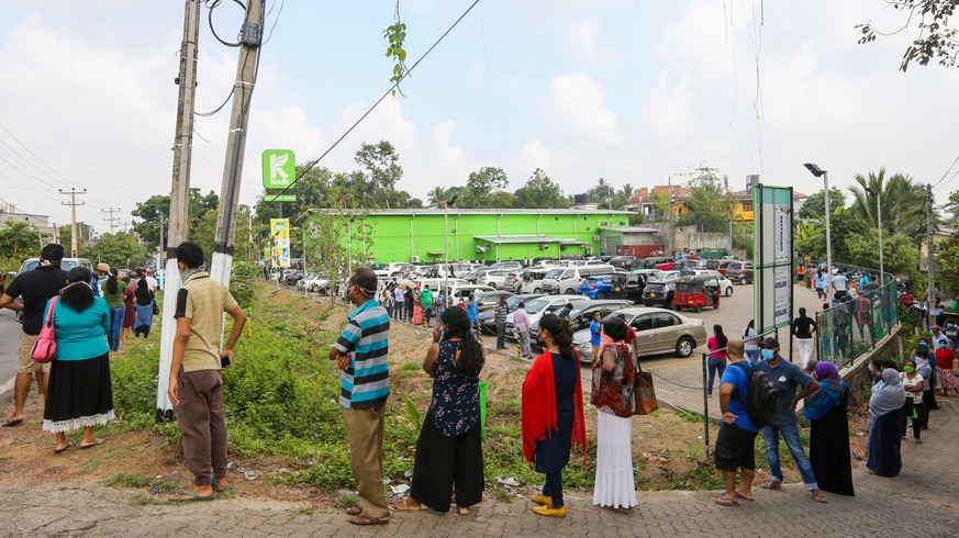 epa08317283 People line up in front of a supermarket while keeping a safe distance from each other amid the coronavirus and COVID-19 pandemic, during a temporary lifting of curfew in Colombo, Sri Lank ...
