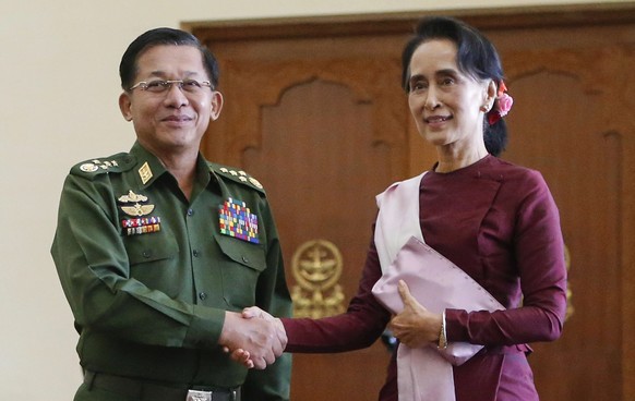 epa08979223 (FILE) - Myanmar pro-democracy leader Aung San Suu Kyi (R), chairperson of National League for Democracy (NLD) party, shakes hand with Myanmar military commander-in-chief Senior General Mi ...