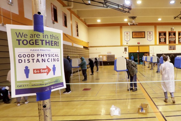Voters practicing social distancing cast ballots at Riverside High School during Wisconsin&#039;s primary election Tuesday April 7, 2020, in Milwaukee. Voters in Wisconsin are waiting in line to cast  ...
