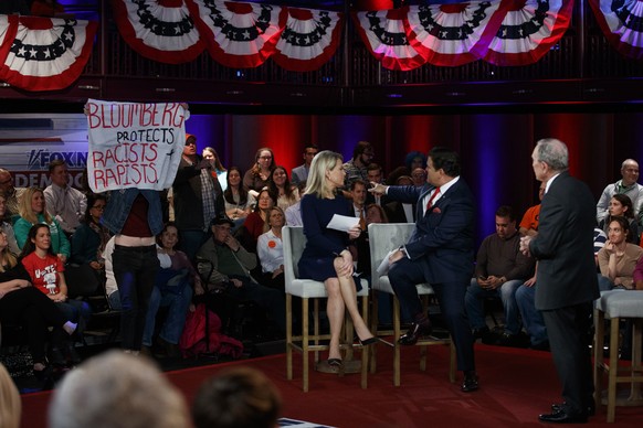 Democratic presidential candidate former New York City Mayor Mike Bloomberg looks to a protester during a FOX News Channel Town Hall, co-moderated by FNC&#039;s chief political anchor Bret Baier of Sp ...