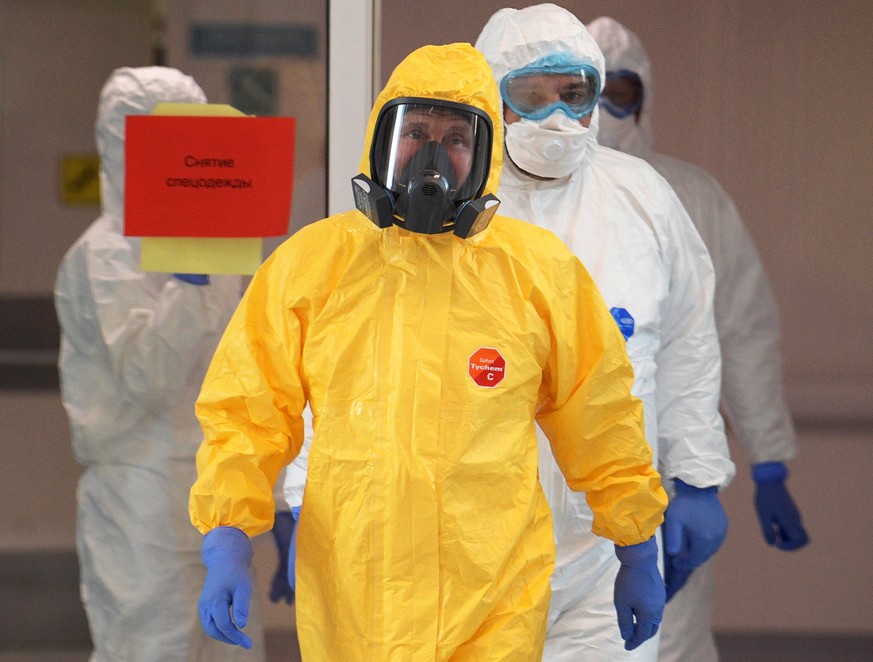 epa08318590 Russian president Vladimir Putin (front) wearing a yellow protective suit visits a hospital for patients with suspected COVID-19 disease caused by the SARS-CoV-2 coronavirus in the Kommuna ...