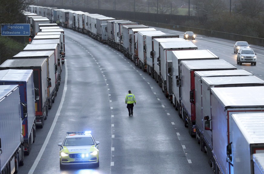 Police patrol along the M20 motorway where freight traffic is parked whilst the Port of Dover remains closed, in Ashford, Kent, England, Tuesday, Dec. 22, 2020. Trucks waiting to get out of Britain ba ...