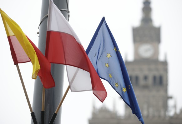 The flags of the European Union, Poland and the city of Warsaw hang in Warsaw, Poland, on Wednesday Dec. 9, 2020. Mayor Rafal Trzaskowski said the city was displaying EU flags around the city as a way ...