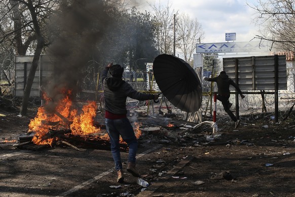 Migrants trying to enter Greece from the Pazarkule border gate, Edirne, Turkey, approach the border gate during clashes in Kastanies village, Saturday, Feb. 29, 2020. Refugees and migrants massed on t ...