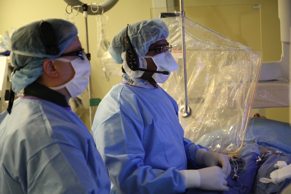 In this undated image provided on Saturday Aug. 29, 2015 by Mount Sinai Hospital in New York shows Dr Vivek Reddy, right, as he checks the screen while doing a surgery to implant the new tiny wireless ...
