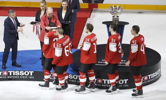 epa06753310 Swiss Defense and Sport Minister Guy Parmelin, 2nd left, next to Rene Fasel, left, President of IIHF, gives the silver medal to Switzerland&#039;s forward Kevin Fiala past #21 teammates fo ...