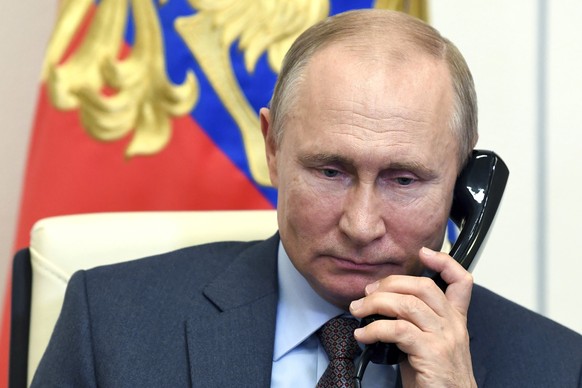 Russian President Vladimir Putin speaks on the phone during a meeting with Russian Prime Minister Mikhail Mishustin via teleconference at the Novo-Ogaryovo residence outside Moscow, Russia, Tuesday, J ...