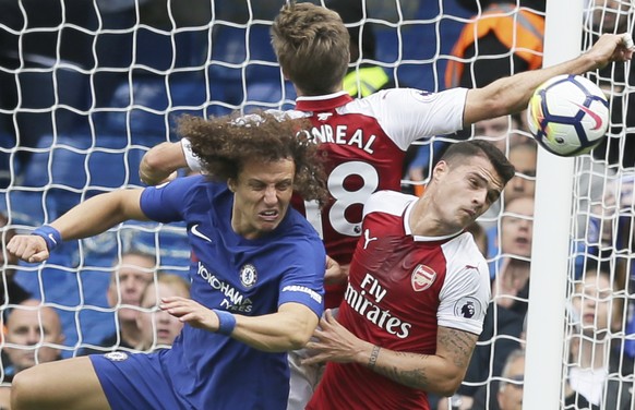 Chelsea&#039;s David Luiz, left, Arsenal&#039;s Granit Xhaka, right, and Arsenal&#039;s Nacho Monreal jump to head the ball during the English Premier League soccer match between Chelsea and Arsenal a ...