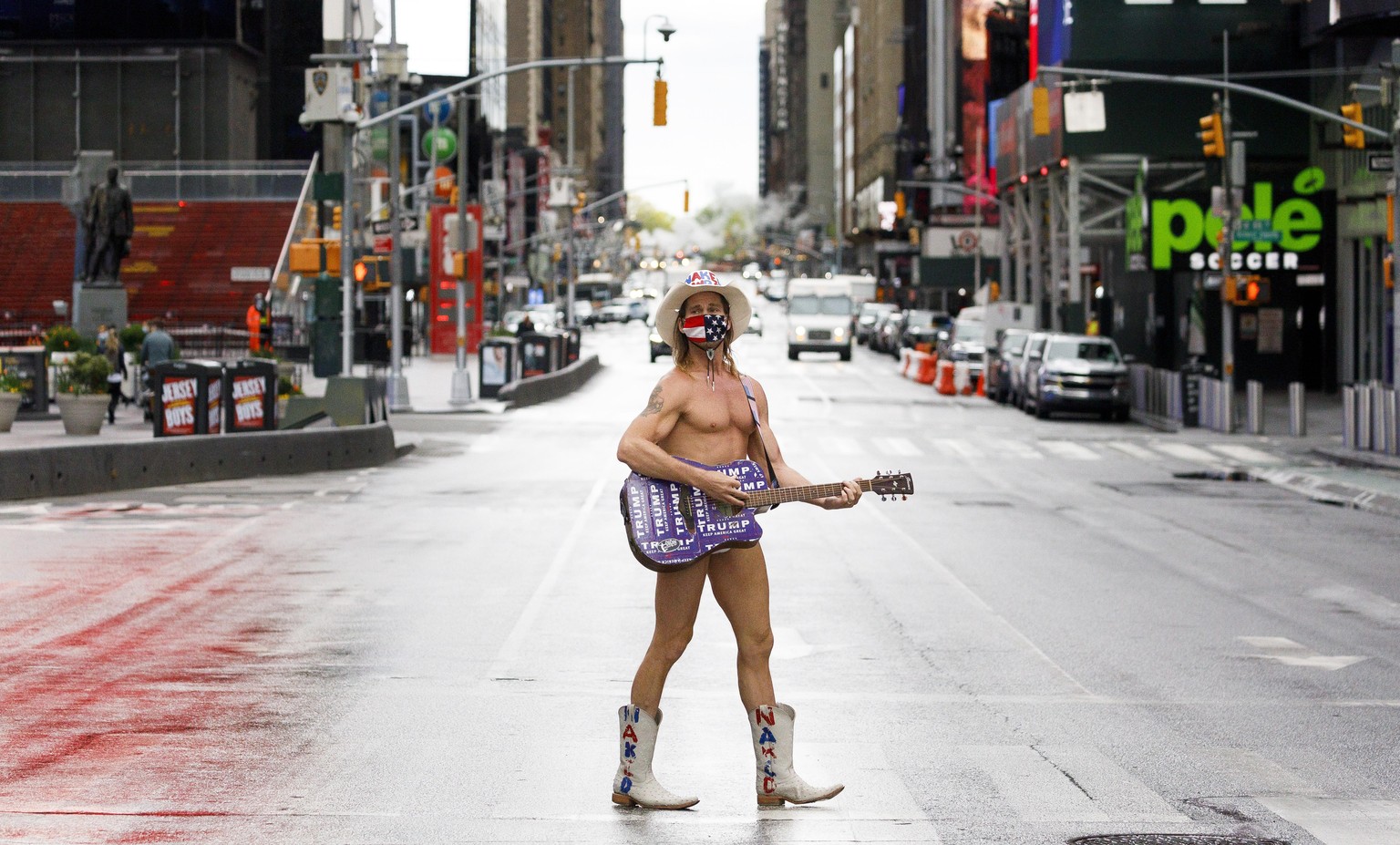 epa08415449 A busker named Robert Burck, known as the Naked Cowboy, stands in the middle of a quiet Times Square in New York, New York, USA, 11 May 2020. EPA/JUSTIN LANE