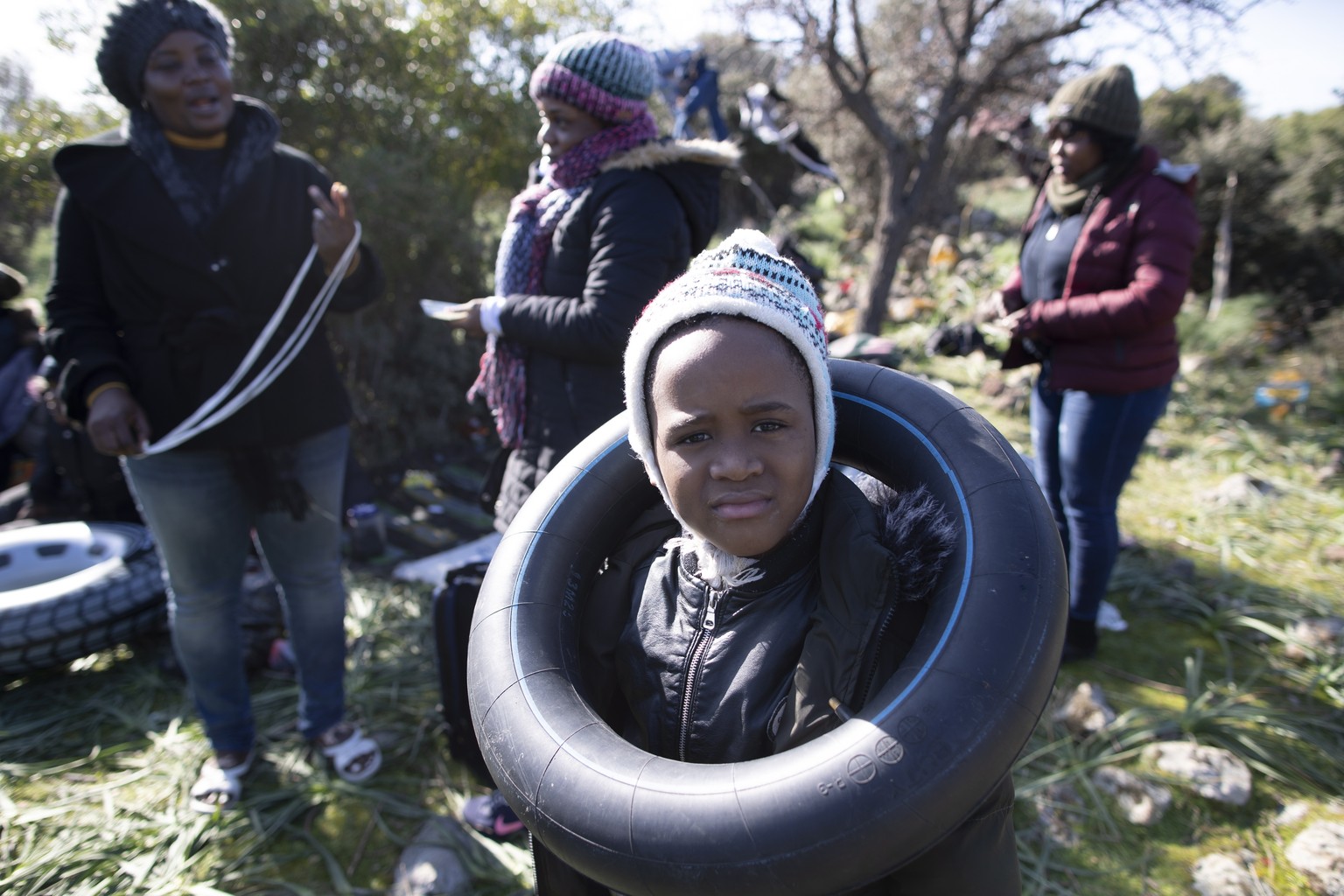epaselect epa08266048 An African migrant boy plays with a rubber ring as they wait before attempting to cross the Agean Sea by boat to reach the Greek island of Lesvos, in Ayvacik district, Canakkale  ...