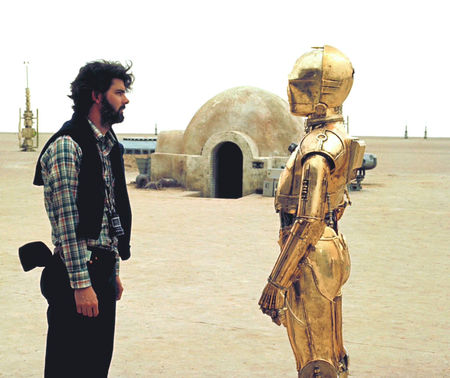 On the set of Star Wars: Episode IV - A New Hope
British actor Anthony Daniels (who plays C-3PO) with American director, screenwriter and producer George Lucas on the set of his movie Star Wars: Episo ...