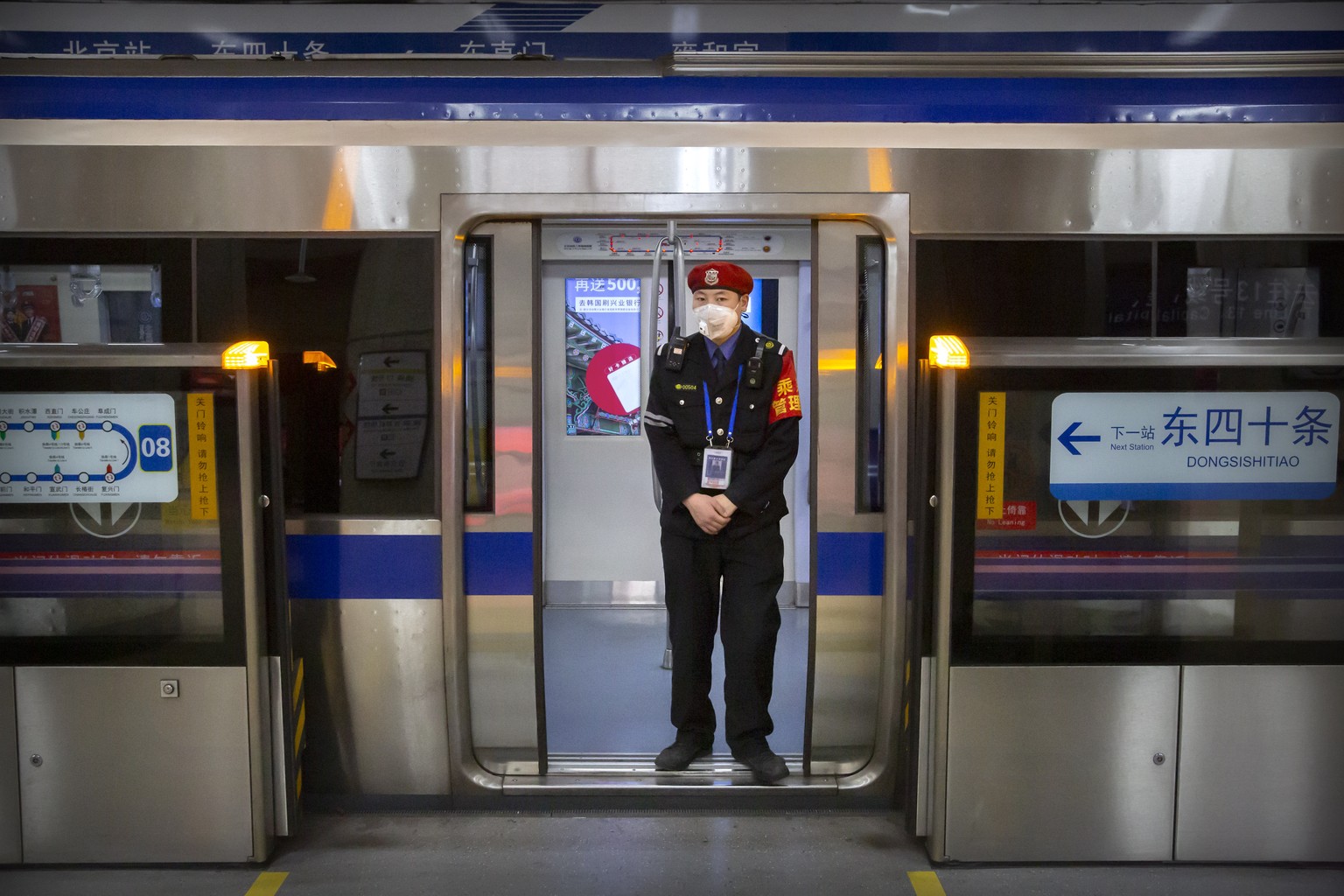 FILE - In this Feb. 3, 2020, file photo, a security officer wearing a face mask stands on a subway train in Beijing. Health authorities are preparing for a possible pandemic as they work to contain a  ...