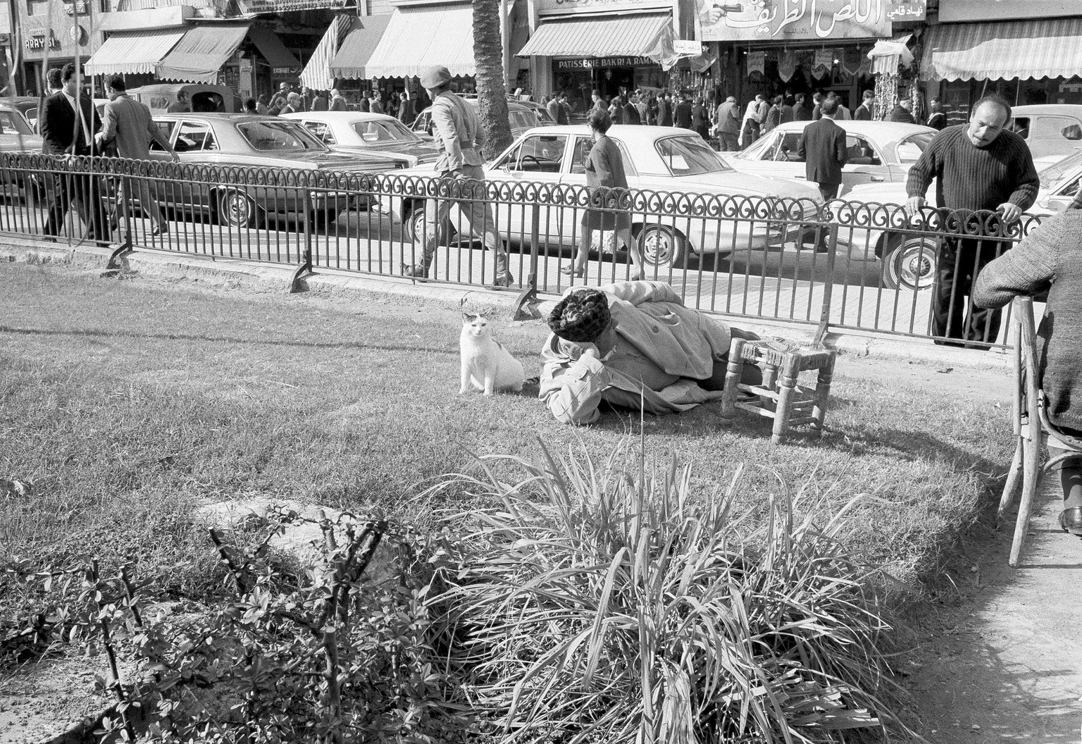A Lebanese person takes a rest on a grassy strip alongside a busy downtown street in Beirut, Lebanon, Feb. 1969. (AP Photo)