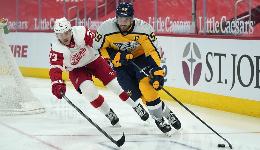 Nashville Predators defenseman Roman Josi (59) protects the puck from Detroit Red Wings left wing Adam Erne (73) in the second period of an NHL hockey game Tuesday, April 6, 2021, in Detroit. (AP Phot ...