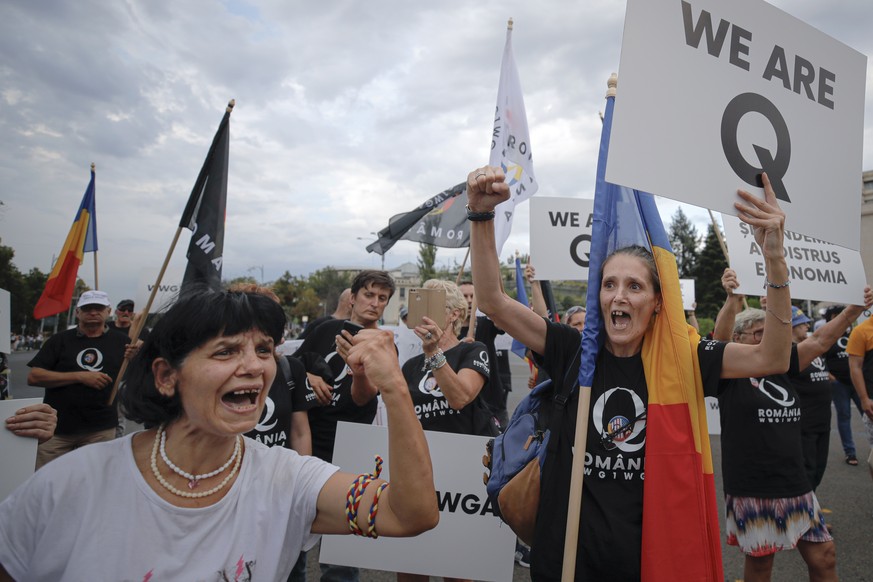 Romanian supporters of QAnon shout slogans against the government&#039;s measures to prevent the spread of COVID-19 infections, like wearing a face mask, during a rally in Bucharest, Romania, Monday,  ...