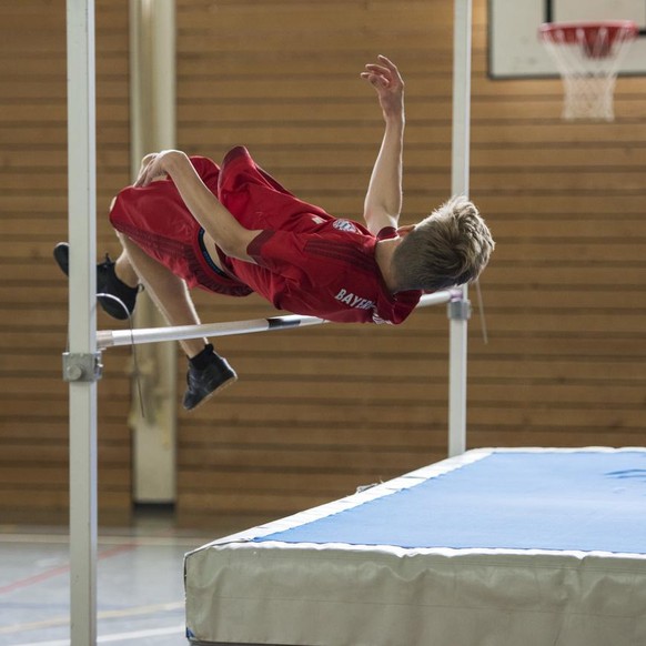 A pupil does the high jump during a physical education lesson of gymnasium classes Bez 2c and Bez 2d, pictured in a sports hall of the Public School Suhr, Canton of Aargau, Switzerland, on June 25, 20 ...