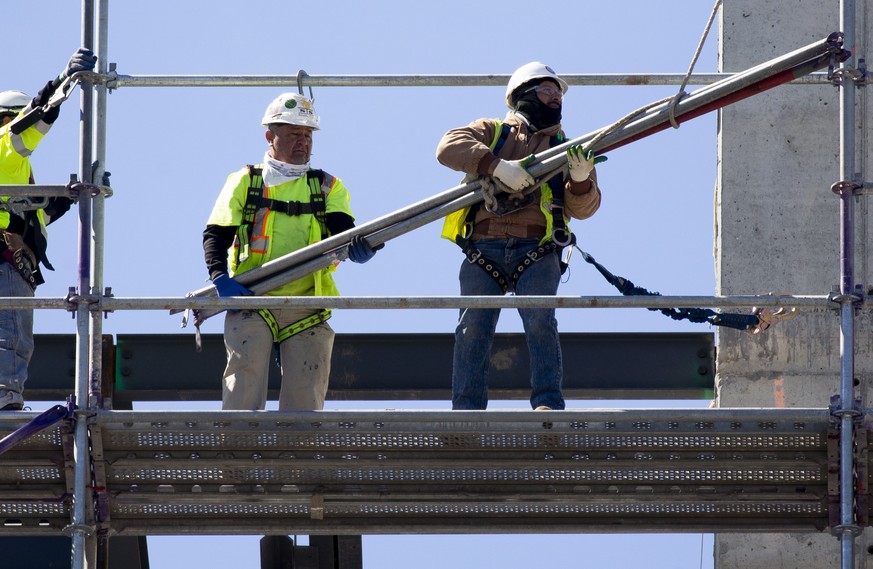 epa09181259 Workers build scaffolding ten stories up at a construction site in Washington, DC, USA, 06 May 2021. Job cuts announced by US-based employers decreased twenty-five percent in April 2021 co ...