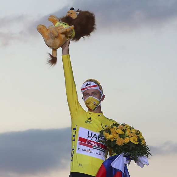 Tour de France winner Slovenia&#039;s Tadej Pogacar, wearing the overall leader&#039;s yellow jersey, celebrates on the podium after the twenty-first and last stage of the Tour de France cycling race  ...