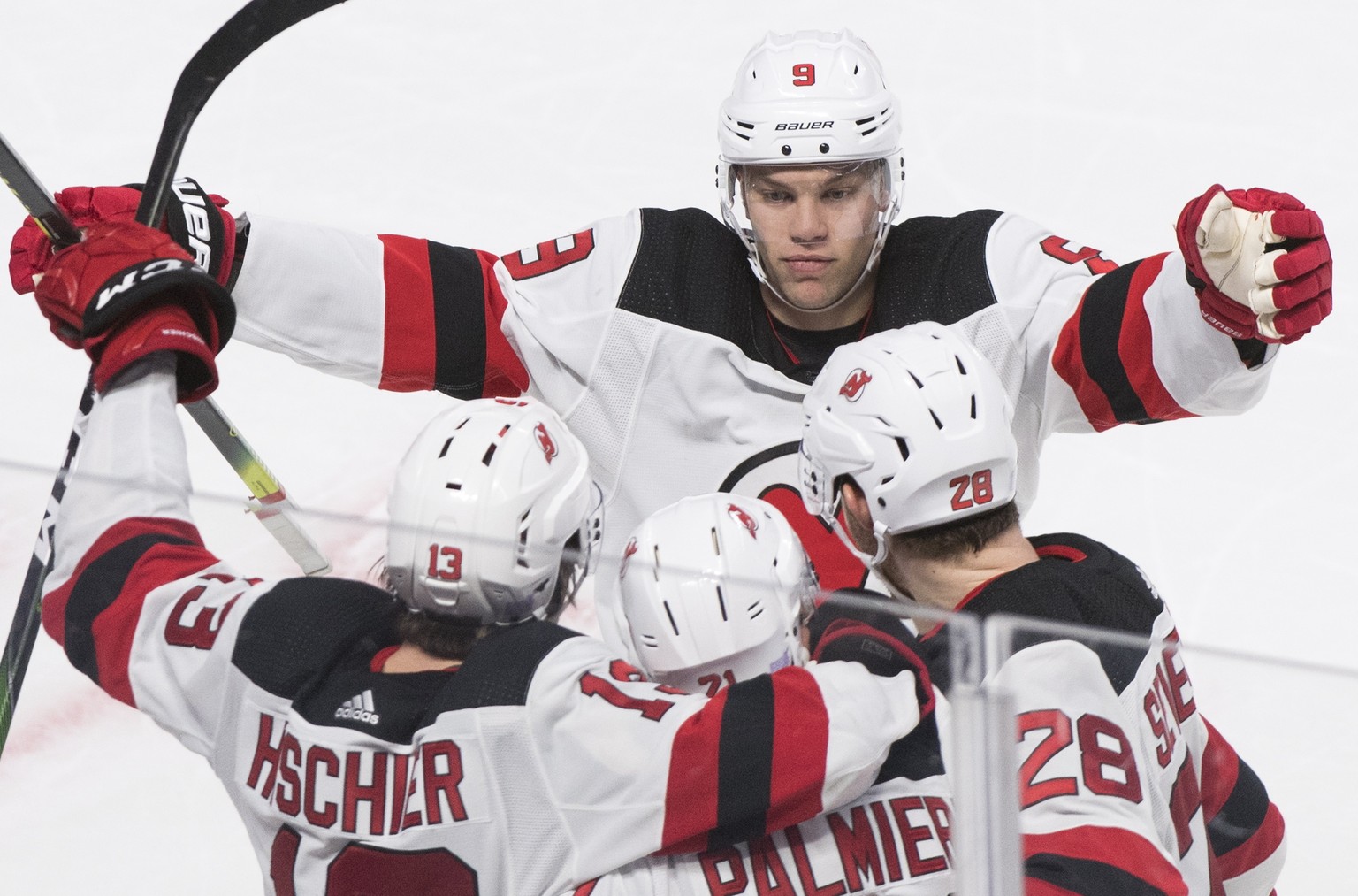 New Jersey Devils&#039; Kyle Palmieri (21) celebrates with teammates Taylor Hall (9), Nico Hischier (13) and Damon Severson (28) after scoring against the Montreal Canadiens during overtime in an NHL  ...
