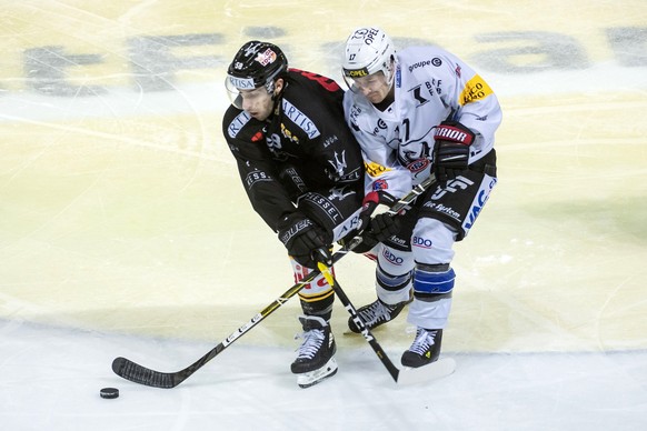 Lugano&#039;s player Romain Loeffel, left, and Gotteron&#039;s player Andrew Miller, right, during the preliminary round game of National League Swiss Championship between HC Lugano and HC Fribourg-Go ...