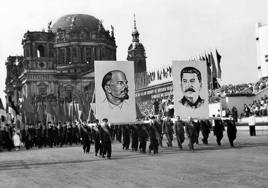An einer 1. Mai Parade anlaesslich der Konferenz der Sozialistischen Einheitspartei Deutschlands marschieren Arbeiter mit Fahnen und Portraits von Lenin und Stalin ueber den Marx Engels-Platz in Ost-B ...