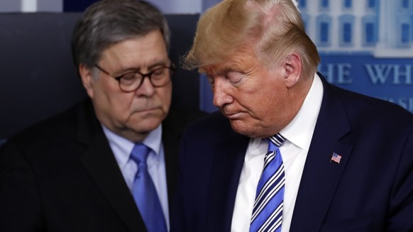 FILE - In this March 23, 2020, file photo President Donald Trump moves from the podium to allow Attorney General William Barr to speak about the coronavirus in the James Brady Briefing Room in Washing ...